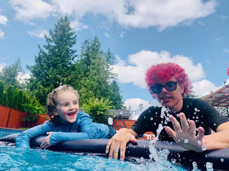 Scott and his cousin play in the pool on a sunny day.